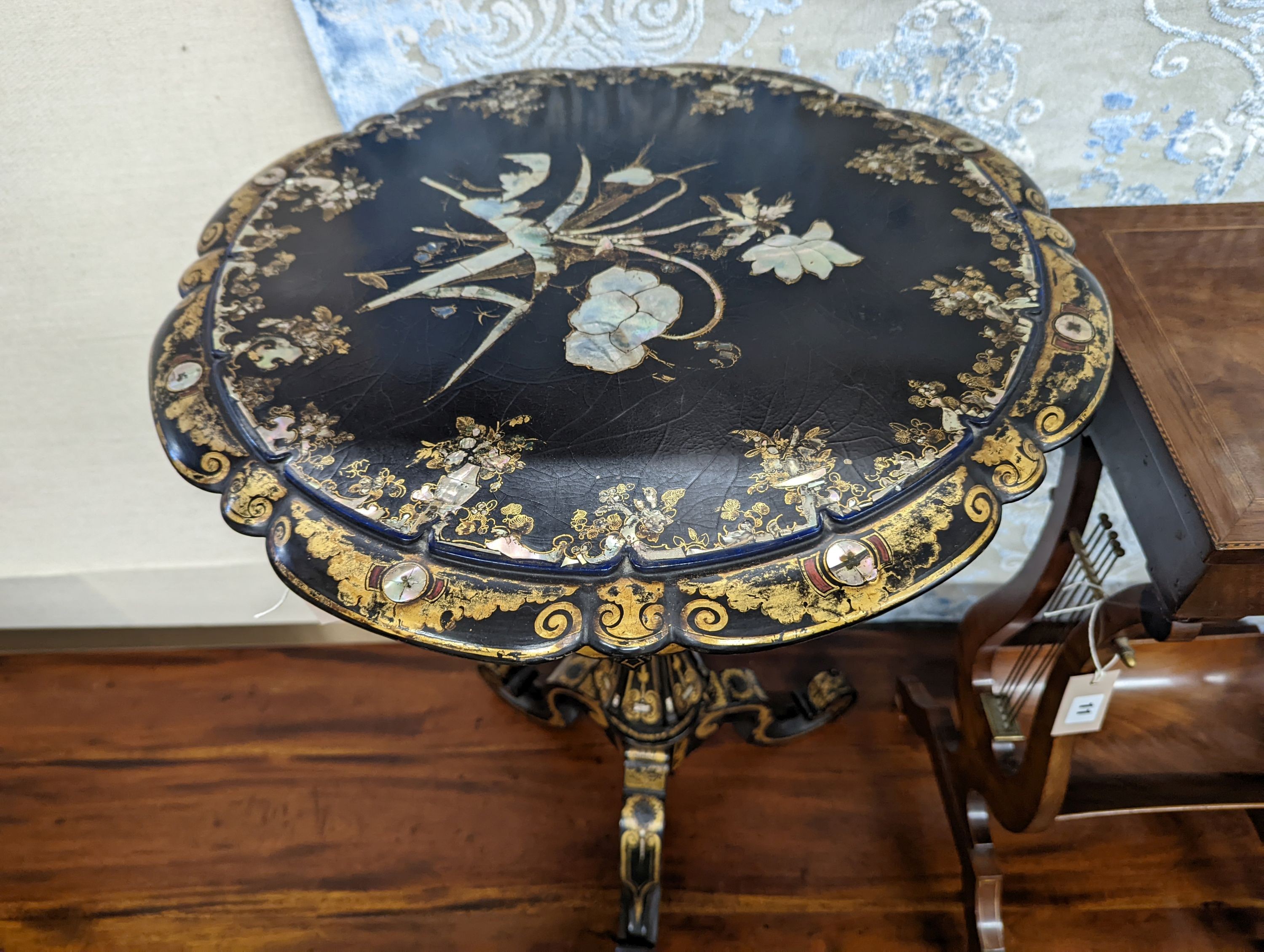 A Victorian mother of pearl inlaid gilt decorated circular tilt top papier mache tripod wine table, diameter 51cm, height 74cm